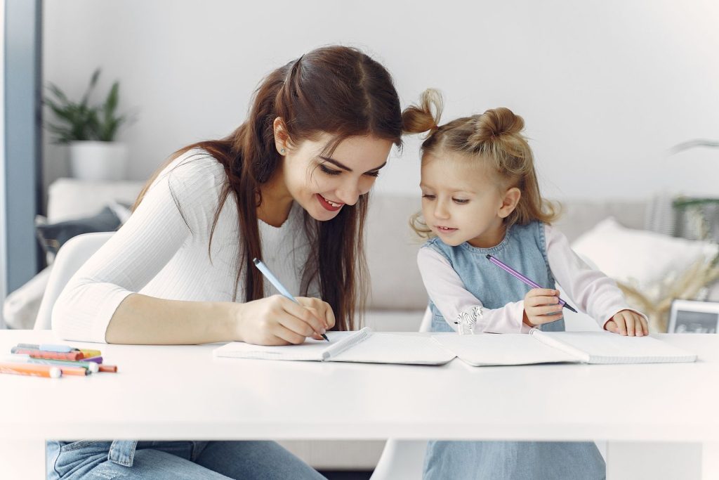 Garde d'enfant aidant une petite fille